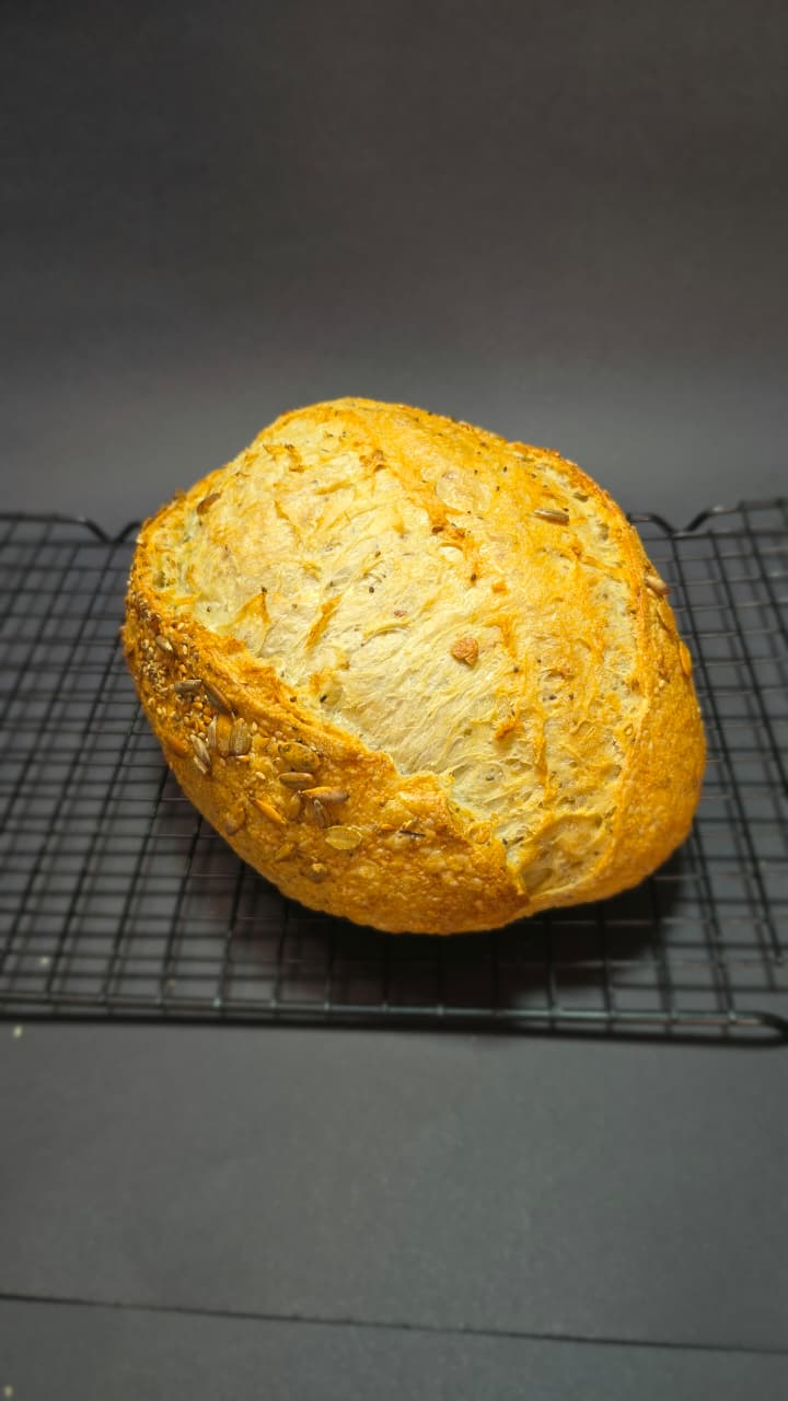Pão redondo coberto de sementes de girassol, abóbora e gergelim